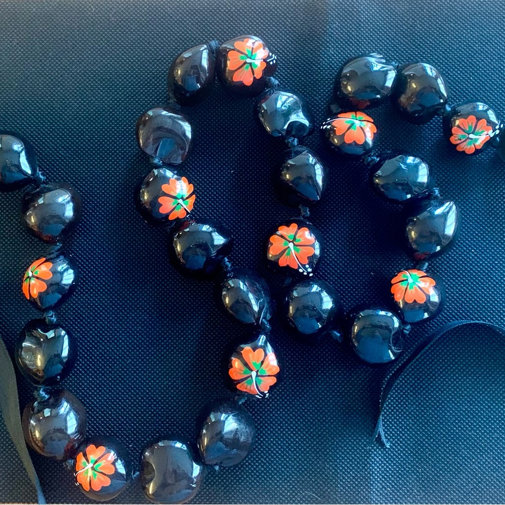 Black Kukui Net Lei with red Hibiscus flowers